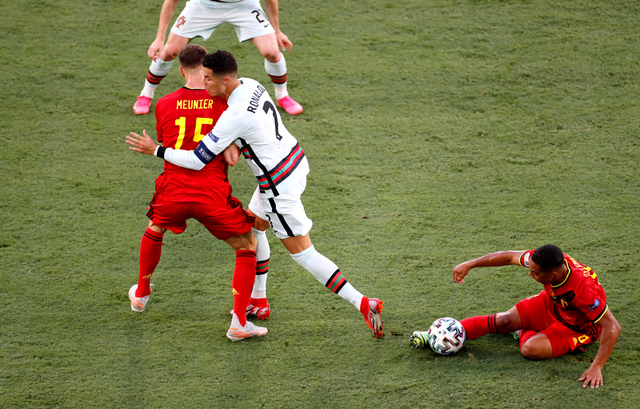 Pemain Portugal Cristiano Ronaldo duel dengan Thomas Meunier dari Belgia di laga 16 Besar Euro 2020 di Stadion La Cartuja, Seville, Spanyol. Foto: Jose Manuel Vidal/Reuters