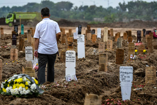Warga berjalan saat akan melakukan ziarah kubur di area pemakaman khusus COVID-19 di TPU Rorotan, Cilincing, Jakarta Utara, Senin (28/6/2021). Foto: M Risyal Hidayat/ANTARA FOTO