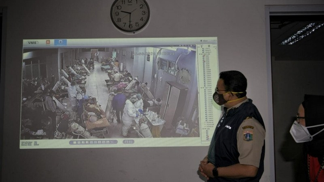 Gubernur DKI Jakarta Anies Baswedan melalui monitor CCTV meninjau kondisi terkini di Rumah Sakit Khusus Daerah (RSKD) Duren Sawit, Jakarta Timur, Senin (29/06) malam. Foto: Dok. Pribadi/ANTARA
