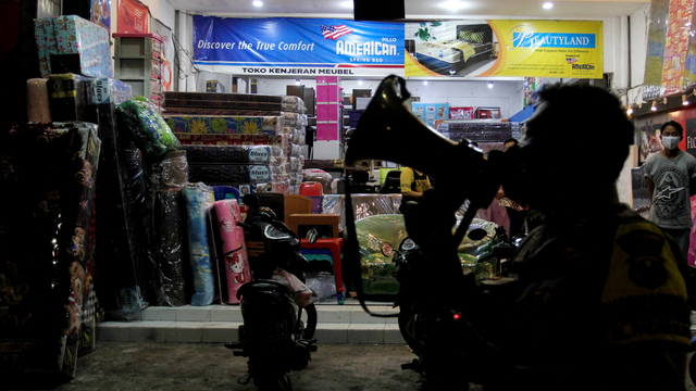 Anggota polisi meminta pedagang untuk segera menutup tempat usahanya saat Pemberlakuan PPKM Mikro, di Jalan Kapas Krampung, Surabaya, Jawa Timur. Foto: Didik Suhartono/ANTARA FOTO