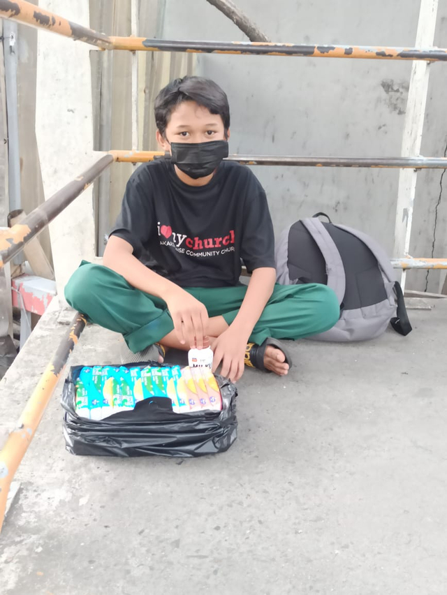 Mulqi saat sedang berjualan tisu di JPO depan Mall Depok Town Square/ Foto : Kamila Sayara Avicena