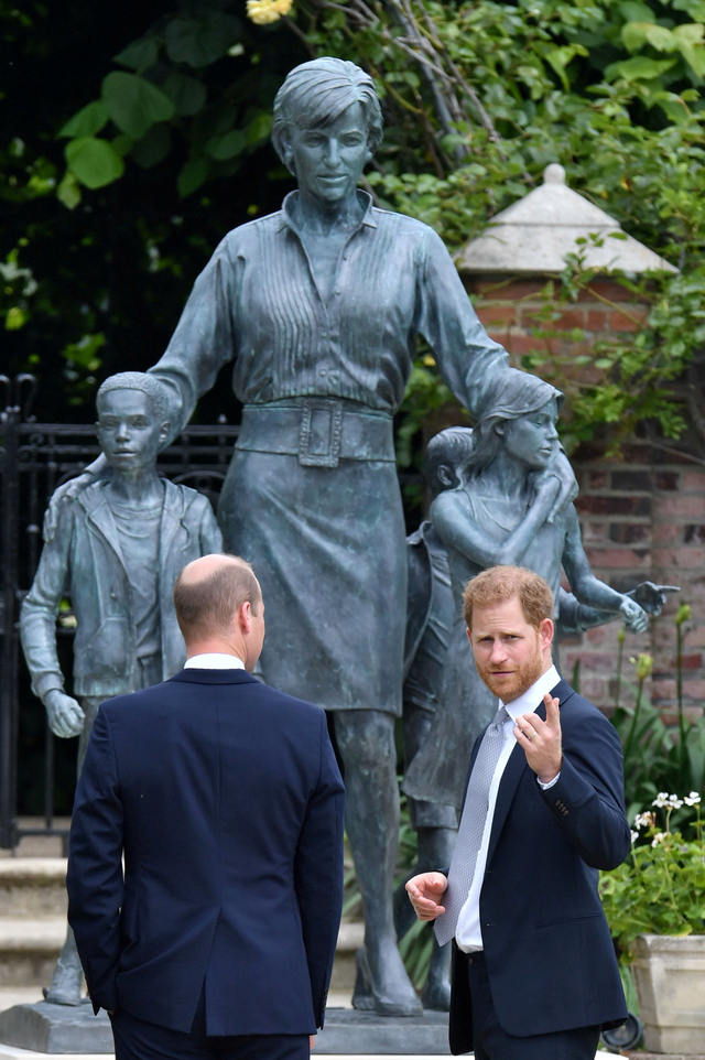 Pangeran William dan Pangeran Harry berbincang usai peresmian patung Putri Diana di Taman Sunken, Istana Kensington, London, Inggris. Foto: Dominic Lipinski/Pool/REUTERS