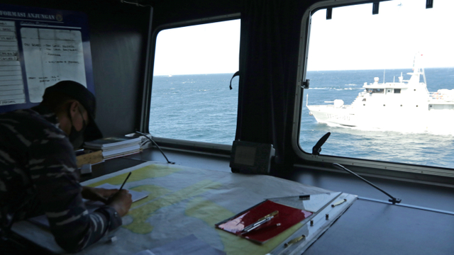 Prajurit TNI AL membuat rute perjalanan dalam melakukan pencarian korban KMP Yunicee yang tenggelam di Selat Bali, Jawa Timur, Jumat (2/7/2021). Foto: Budi Candra Setya/ANTARA FOTO