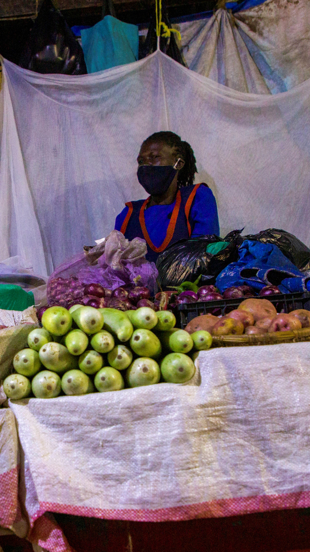 Seorang pedagang bersiap tidur di samping dagangan mereka di Pasar Nakasero di Kampala, Uganda. Foto: BADRU KATUMBA/AFP