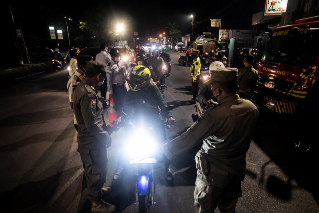 Petugas gabungan memeriksa identitas pengendara  motor saat PPKM Darurat di Jalan Raya Bogor, Jakarta, Jumat (2/7/2021). Foto: Muhammad Adimaja/Antara Foto