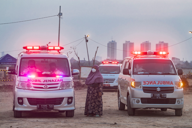 Warga menunggu jenazah keluarganya untuk dimakamkan dengan protokol COVID-19  di TPU Rorotan, Cilincing, Jakarta, Minggu (4/7).  Foto: Muhammad Adimaja/ANTARA FOTO