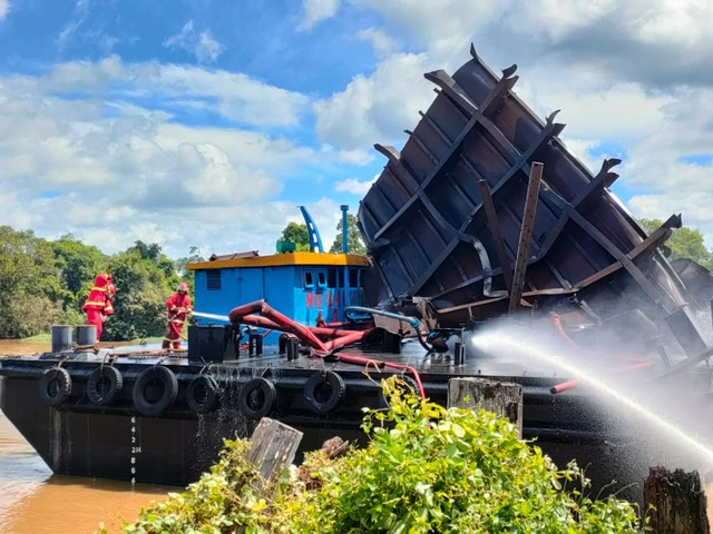 Petugas Damkra Kobar melakukan pemadaman tongkang yang meledak di area PT Korindo Ariabima Sari. Foto: Damkar Kobar