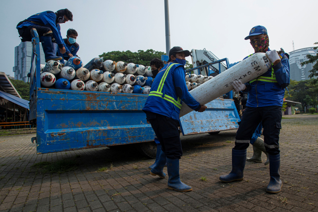 Sejumlah petugas menurunkan tabung berisi oksigen dari truk di Posko Darurat Oxygen Rescue, kawasan Monumen Nasional (Monas), Jakarta, Senin (5/7). Foto: Aditya Pradana Putra/ANTARA FOTO