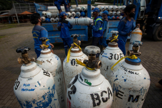 Sejumlah petugas menurunkan tabung berisi oksigen di Posko Darurat Oxygen Rescue, kawasan Monumen Nasional (Monas), Jakarta, Senin (5/7).  Foto: Aditya Pradana Putra/ANTARA FOTO