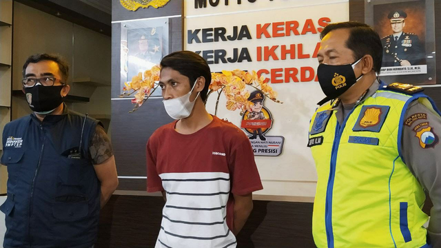 Aji Prasetyo Utomo (23), pelaku  hoax korban laka akibat pemadaman lampu jalan di Malang saat memberikan klarifikasi di Mapolresta Malang Kota, Senin (6/7/2021) malam. Foto/Azmy.