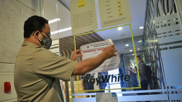 Gubernur DKI Jakarta Anies Baswedan memasang surat penghentian aktivitas saat menyidak gedung-gedung perkantoran di Jakarta bersama Kepolisian, Satpol PP dan Disnaker. Foto: Instagram/@aniesbaswedan