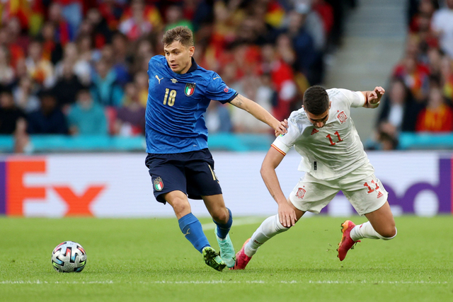 Pemain Italia Nicolo Barella berusaha melewati pemain Spanyol Ferran Torres pada pertandingan semi final Euro 2020 di Stadion Wembley, London, Inggris. Foto: Carl Recine/REUTERS