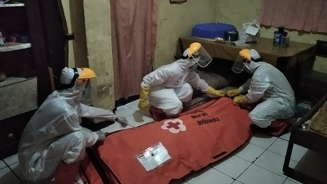 Petugas mengevakuasi warga Kabupaten Tegal yang meninggal saat isolasi mandiri. 