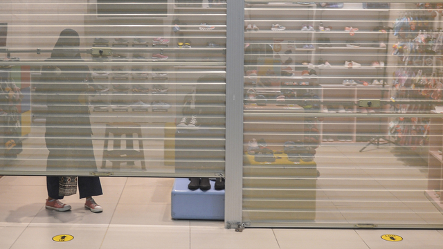 Seorang pegawai menutup tokonya di salah satu Mal di Jakarta pada penerapan PPKM darurat. Foto: ANTARA FOTO/M Risyal Hidayat