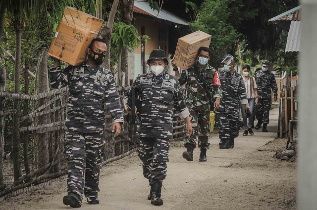 Sejumlah personel TNI AL membawa kebutuhan logistik untuk melakukan Serbuan Vaksinasi COVID-19 di Pulau Kinabuhutan, Minahasa Utara, Sulawesi Utara. Foto: Adwit B Pramono/ANTARA FOTO