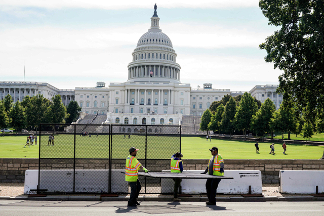 Pekerja mencopot pagar keamanan setelah serangan 6 Januari di Gedung Capitol di Washington, Amerika Serikat. Foto: Joshua Roberts/Reuters