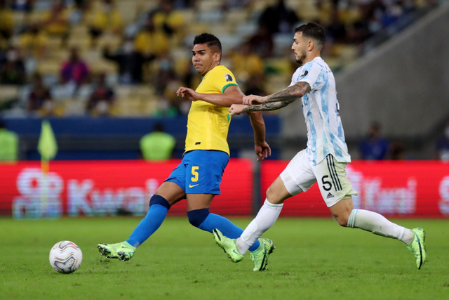 Pemain Argentina Leandro Paredes berebut bola dengan pemain Brasil Casemiro pada pertandingan Final Copa America 2021 di Estadio Maracana, Rio de Janeiro, Brasil. Foto: Amanda Perobelli/REUTERS