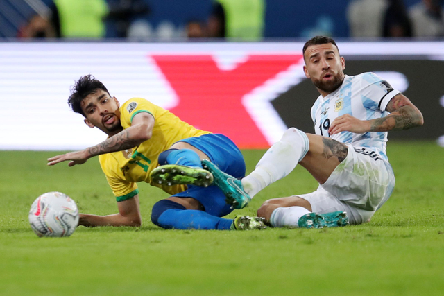 Pemain Argentina Nicolas Otamendi berebut bola dengan pemain Brasil Lucas Paqueta pada pertandingan Final Copa America 2021 di Estadio Maracana, Rio de Janeiro, Brasil. Foto: Ricardo Moraes/REUTERS