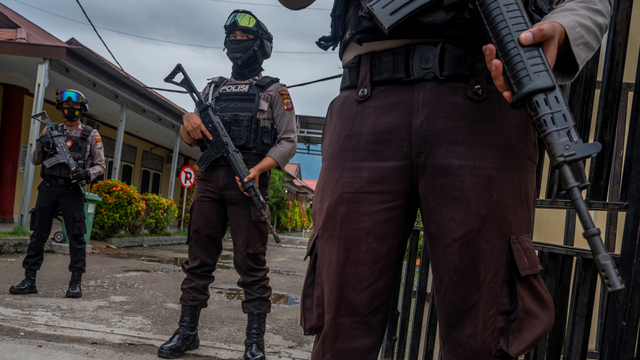 Polisi berjaga di depan gerbang Rumah Sakit Bhayangkara, lokasi identifikasi dua jenazah dari kelompok DPO MIT Poso di Palu, Sulawesi Tengah, Minggu (11/7). Foto: Basri Marzuki/ANTARA FOTO