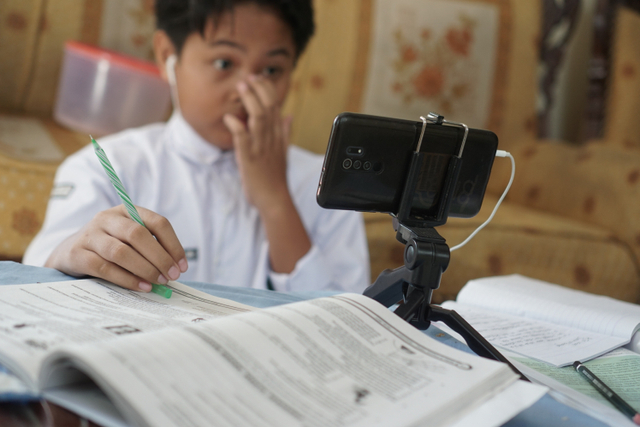 Siswa baru SMP Negeri II Surakarta mengikuti kegiatan belajar mengajar hari pertama masuk sekolah secara daring dari rumah di Kerten, Solo, Jawa Tengah, Senin (12/7). Foto: Mohammad Ayudha/ANTARA FOTO