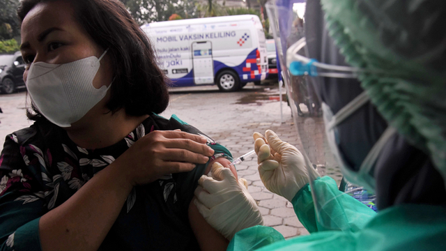 Petugas kesehatan menyuntikkan vaksin Sinovac kepada warga saat mobil vaksin keliling singgah di Kantor Kelurahan Cipedak, Jakarta, Selasa (13/7/2021). Foto: Indrianto Eko Suwarso/ANTARA FOTO
