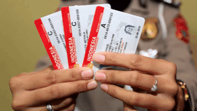 Petugas menunjukkan Surat Izin Mengemudi (SIM). Foto: Syifa Yulinnas/ANTARA FOTO