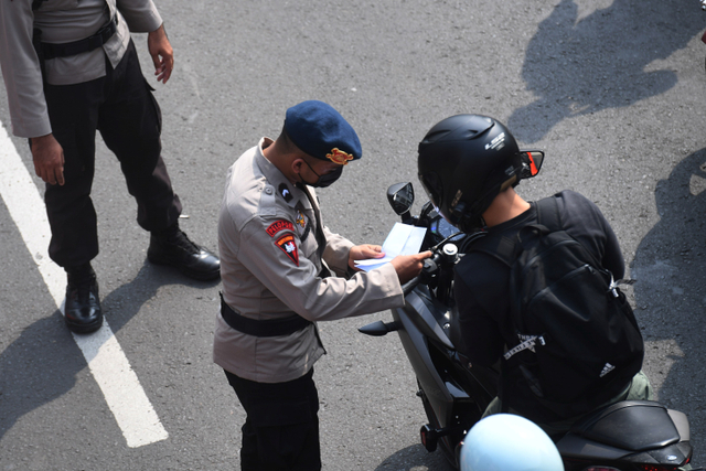 Anggota Polisi memeriksa dokumen warga saat melintasi titik penyekatan baru di Mampang, Jakarta, Kamis (15/7).  Foto: Akbar Nugroho Gumay/ANTARA FOTO