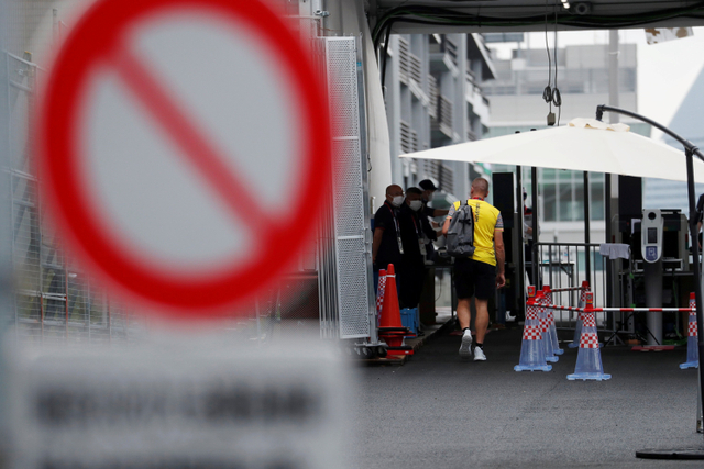 Seorang ofisial tim Belgia berjalan menuju pos pemeriksaan keamanan di pintu masuk Wisma Atlet Olimpiade Tokyo 2020 di Tokyo, Jepang. Foto: Issei Kato/REUTERS