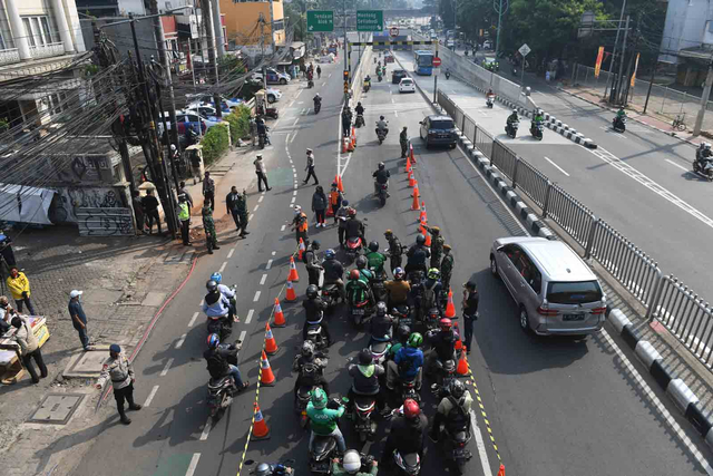 Petugas menghentikan kendaran sepeda motor di titik penyekatan baru di Mampang, Jakarta Selatan, Kamis (15/7/2021). Foto: Akbar Nugroho Gumay/ANTARA FOTO