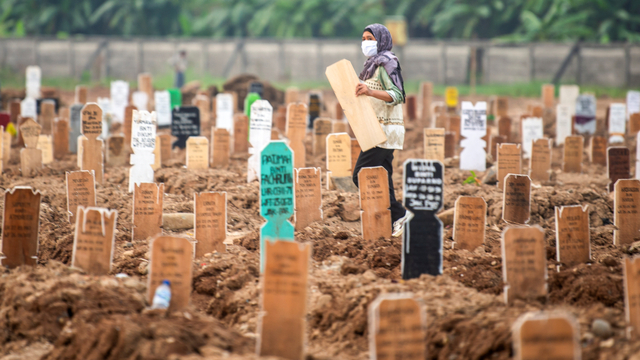 Warga membawa nisan keluarganya di area pemakaman khusus COVID-19 di TPU Rorotan, Cilincing, Jakarta Utara, Kamis (15/7/2021). Foto: M Risyal Hidayat/ANTARA FOTO