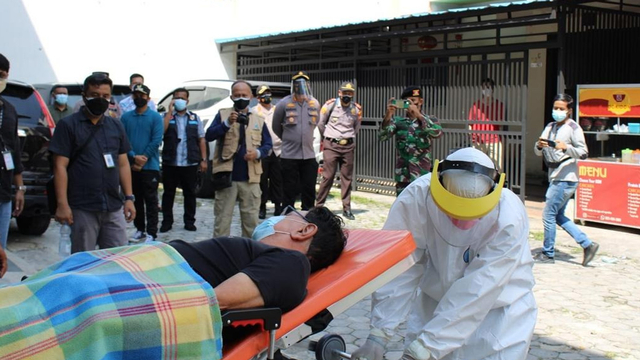 PASIEN positif COVID-19 dievakuasi oleh tenaga kesehatan (Nakes) mengenakan pakaian Alat Pelindung DIri (APD) lengkap ke mobil Ambulance untuk dibawa ke Rumah Sakit Daerah (RSD) Madani, Pekanbaru, Kamis (15/7/2021).