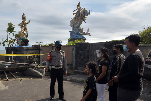 Anggota Polisi menegur warga yang hendak memasuki area Pantai Pererenan, Badung, Bali, Sabtu (17/7/2021). Foto: Nyoman Hendra Wibowo/Antara Foto