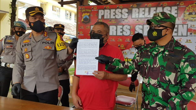 Kepala Desa Jenar, Samto (berkaos merah) membuat surat permintaan maaf di Polres Sragen