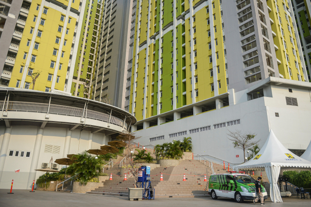 Petugas berjalan di depan ambulans di Rusun Pasar Rumput, Manggarai, Jakarta, Minggu (18/7).  Foto: M Risyal Hidayat/ANTARA FOTO
