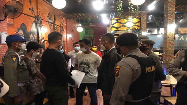 TIM Gabungan terdiri dari Satpol PP, Polisi dan TNI, merazia tempat usaha di Jalan Arifin Achmad, Pekanbaru, masih buka diluar jam selama pemberlakuan PPKM Skala Mikro Diperketat.