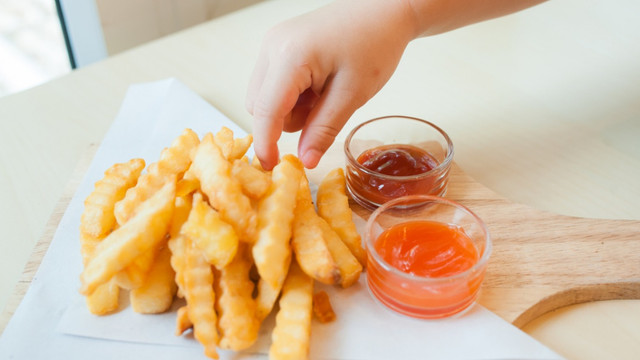 Anak mengambil kentang goreng. Foto: Shutter Stock