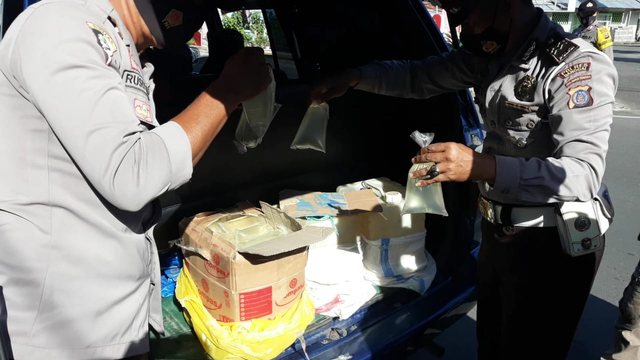 Polisi saat menyita 90 liter cap tikus dari mobil minibus di Luwuk, Kabupaten Banggai, Rabu (21/7) 08.30 WITA. [Foto: Istimewa]