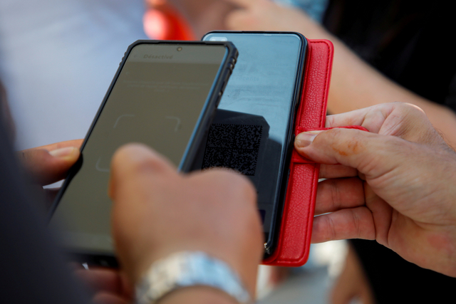 Petugas mengecek paspor kesehatan sebelum memasuki Museum Louvre di Paris, Prancis. Foto: Sarah Meyssonnier/Reuters
