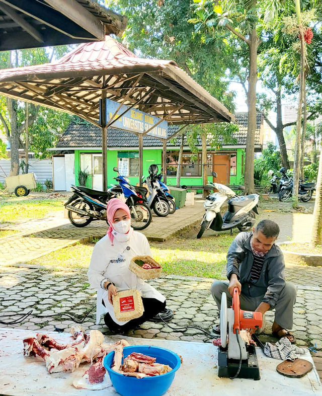 Rektor Universitas Gajayana Prof. Dr. Dyah Sawitri, SE, MM, saat turut membungkus daging kurban. 