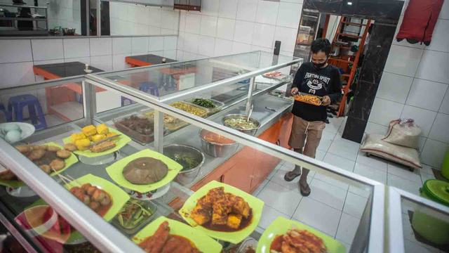 Pekerja menyiapkan lauk pauk di Warteg Subsidi Bahari, Pejaten, Jakarta, Kamis (22/7/2021).  Foto: Aprillio Akbar/ANTARA FOTO