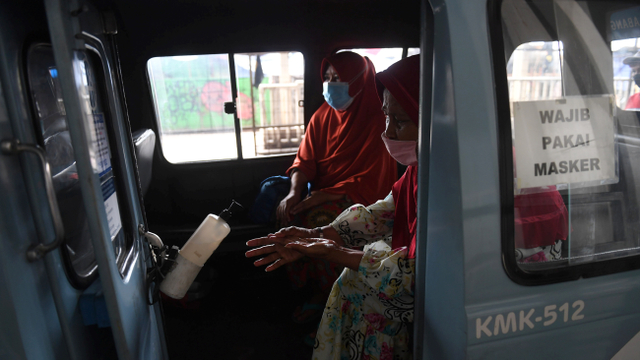 Penumpang menggunakan cairan pembersih tangan yang disediakan di dalam angkutan Jak Lingko di Tanah Abang, Jakarta, Kamis (22/7/2021). Foto: Akbar Nugroho Gumay/ANTARA FOTO