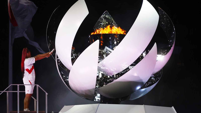 Naomi Osaka dari Jepang menyalakan api Olimpiade pada upacara pembukaan Olimpiade di Jepang. Foto: Kai Pfaffenbach/REUTERS