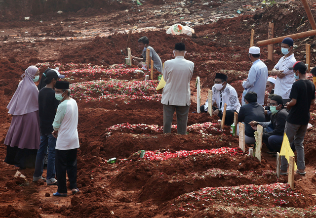 Warga menghadiri pemakaman keluarganya di lahan baru tempat pemakaman umum (TPU) khusus COVID-19, Jombang, Tangerang Selatan, Banten, Jumat (23/7/2021). Foto: Muhammad Iqbal/Antara Foto