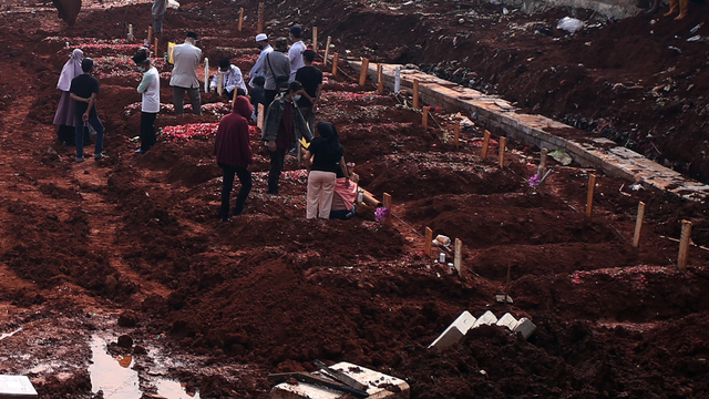 Warga menghadiri pemakaman keluarganya di lahan baru tempat pemakaman umum (TPU) khusus COVID-19, Jombang, Tangerang Selatan, Banten, Jumat (23/7/2021). Foto: Muhammad Iqbal/Antara Foto