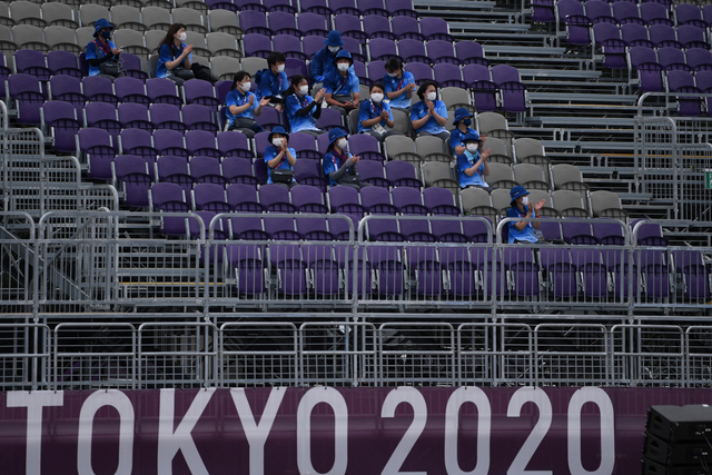 Sejumlah relawan beristirahat sambil memberikan dukungan saat pertandingan panahan Olimpiade Tokyo 2020 di Yumenoshima Park Archery Field, Tokyo, Jepang, Senin (26/7). Foto: Sigid Kurniawan/ANTARA FOTO