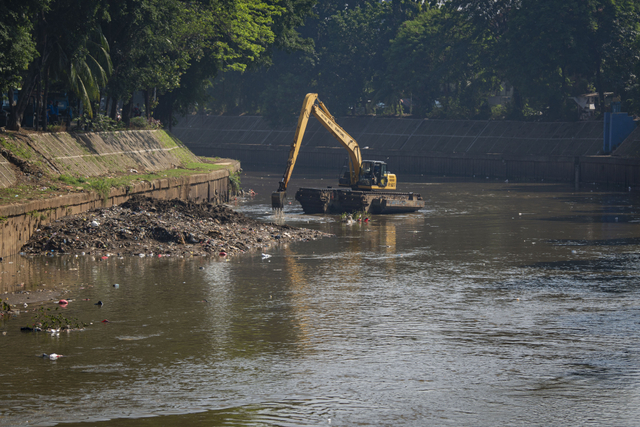 Petugas menggunakan ekskavator untuk mengeruk lumpur sedimentasi Sungai Ciliwung di Kampung Melayu, Jakarta, Selasa (27/7/2021). Foto: Aditya Pradana Putra/Antara Foto