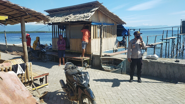 Kapolsek Bunta Iptu Nanang Afriko saat memberitahukan kepada warga yang berada di pesisir pantai Kecamatan Bunta, Kabupaten Banggai, Sulteng agar tidak panik berlebihan dan tidak mempercayai berita bohong. [Foto: Istimewa]