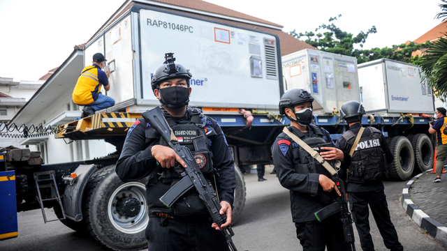 Petugas Brimob Polda Jabar berjaga di samping kontainer yang membawa bahan baku vaksin COVID-19 Sinovac saat tiba di Bio Farma, Bandung, Jawa Barat, Selasa (27/7/2021). Foto: Raisan Al Farisi/ANTARA FOTO
