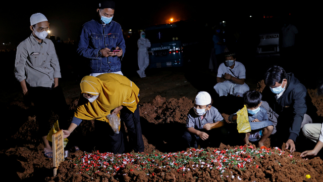 Warga berziarah di dekat pusara keluarganya di area pemakaman khusus COVID-19 di Bekasi, Jawa Barat, Selasa (27/7). Foto: Willy Kurniawan/REUTERS