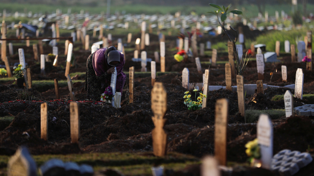 Warga berziarah di dekat pusara keluarganya di area pemakaman khusus COVID-19 di Bekasi, Jawa Barat, Selasa (27/7). Foto: Willy Kurniawan/REUTERS
